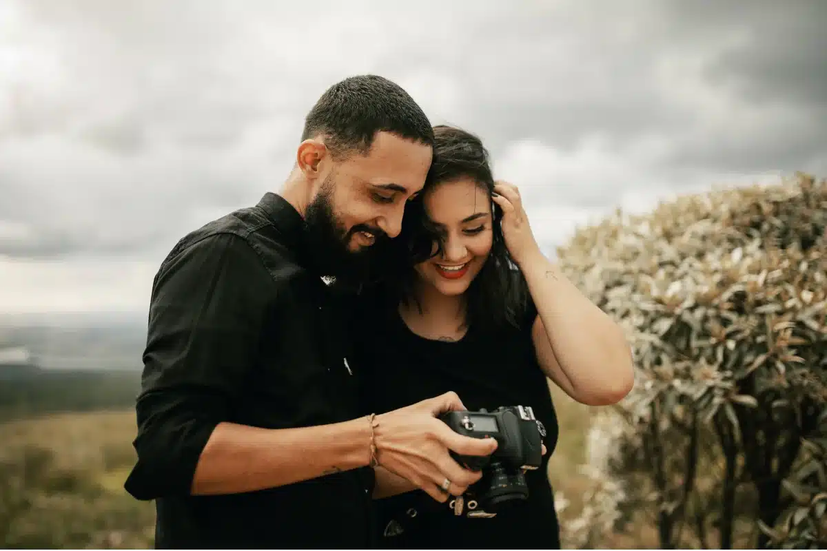 Couple working together at an outdoor event photoshoot with professional DSLR cameras and lenses